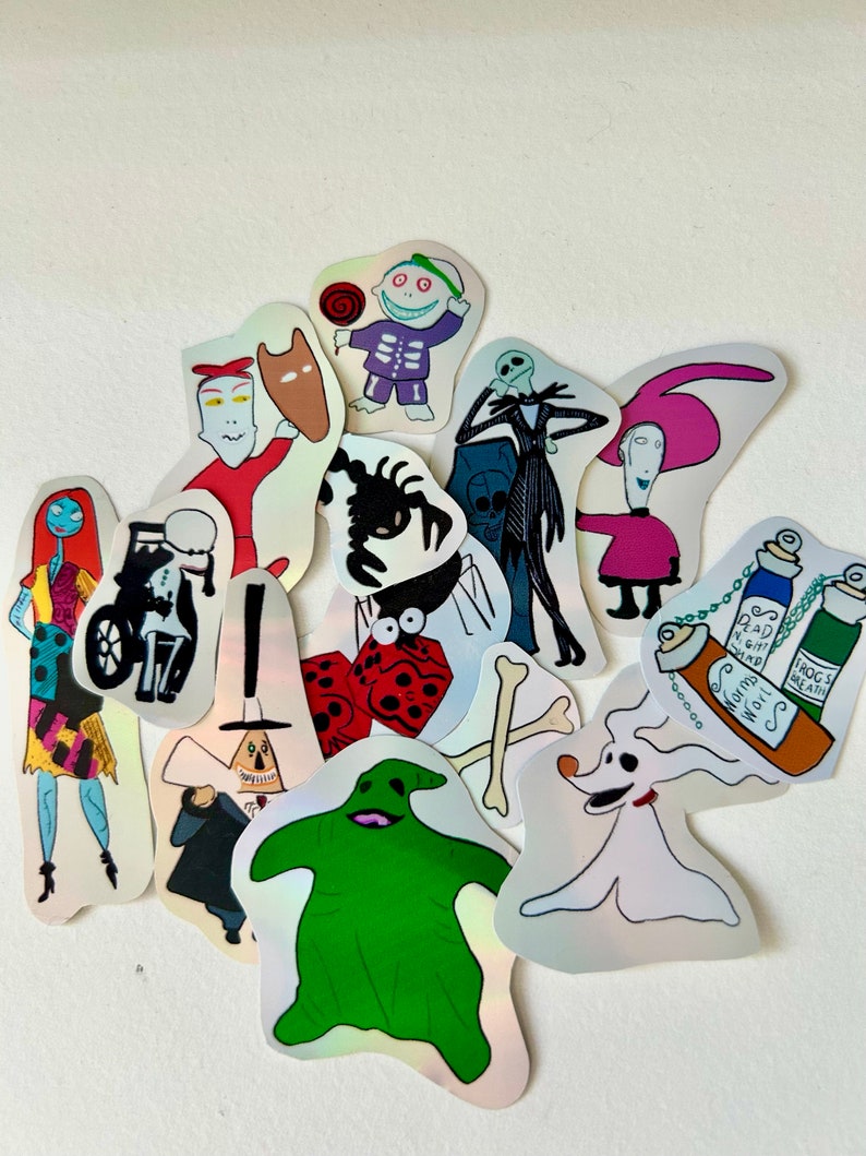Op de afbeelding: Een set van 14 holografische stickers met personages uit de film Nightmare Before Christmas. De stickers bevatten personages zoals Jack Skellington, Sally, Oogie Boogie en Zero. De stickers zijn perfect om een ​​spookachtige touch toe te voegen aan je laptop, waterfles of planner.