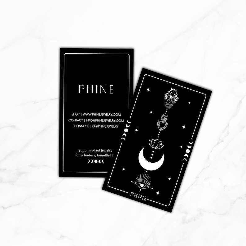 May include: Black and white business card with the text "PHINE" and the website address "www.phinejewelry.com". The card also includes the text "yoga-inspired jewelry for a badass, beautiful" and a crescent moon with stars.