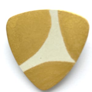 May include: A gold-coloured guitar pick with a white geometric design. The pick is triangular with rounded edges. The design is a white shape resembling a stylized letter "Y".