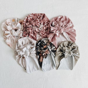 Könnte beinhalten: Eine Sammlung von sechs bunten Stoff-Haarband mit verschiedenen Mustern, darunter florale, geometrische und abstrakte Designs. Die Haarband sind in einem Kreis auf weißem Hintergrund angeordnet.