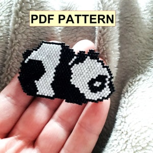 May include: A black and white beaded panda bear pattern. The pattern is for a beaded project, such as a keychain or a charm.