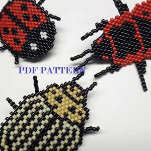 May include: Three beaded bug ornaments, one red and black, one black and white, and one black and cream. The red and black bug has a red body with black spots and black legs. The black and white bug has a black body with white spots and black legs. The black and cream bug has a black body with cream spots and black legs. The bugs are all about 2 inches long.