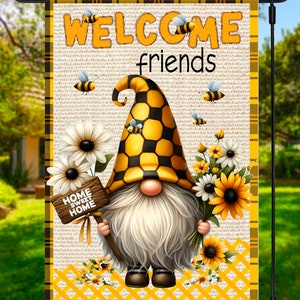 May include: A garden flag featuring a gnome with a long white beard and a yellow and black checkered hat. The flag reads "WELCOME friends" and "HOME SWEET HOME". Bees and flowers decorate the flag.