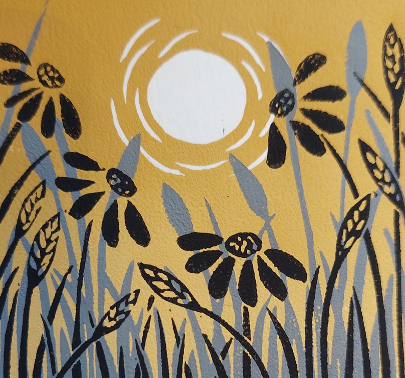 May include: A linocut print of a stylized sun with a white circle and rays, set against a yellow background. Black and gray stylized flowers and grass are in the foreground.