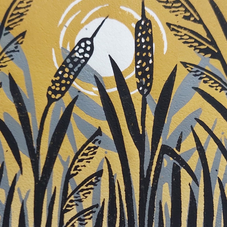 May include: A black and white linocut print of tall grasses with cattails in a yellow and grey background.