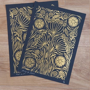 May include: Two art prints with gold floral designs on a dark blue background. The prints feature intricate botanical patterns, including flowers and foliage. The text "Temple of Flowers" and artist's signature are visible.