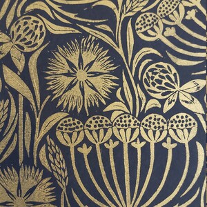 May include: Close-up of a navy blue floral pattern with gold-colored botanical illustrations. The design features stylized flowers, leaves, and seed heads. The repeating pattern creates a rich, textured look, suitable for wallpaper or fabric.