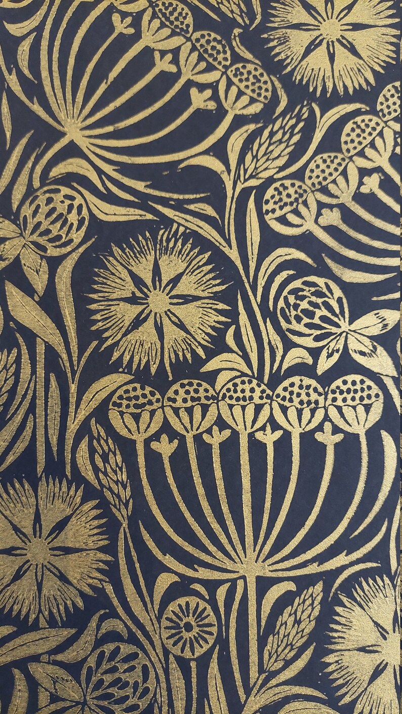May include: Close-up of a navy blue floral pattern with gold-colored botanical illustrations. The design features stylized flowers, leaves, and seed heads. The repeating pattern creates a rich, textured look, suitable for wallpaper or fabric.