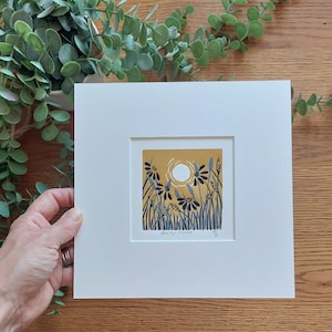 May include: A framed print of a yellow and blue illustration of a field of flowers with a sun in the background. The print is signed "Daisy Field" and numbered 20.