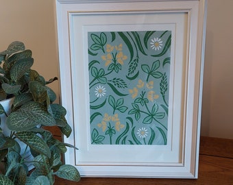 May include: A framed print with a green background and a repeating pattern of white flowers, yellow flowers, and green leaves.