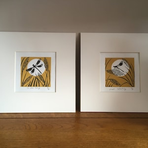 May include: Two framed prints of black and white dragonfly illustrations on a yellow background with white circles. The top print says "In the Wing" and the bottom print says "Just Resting".