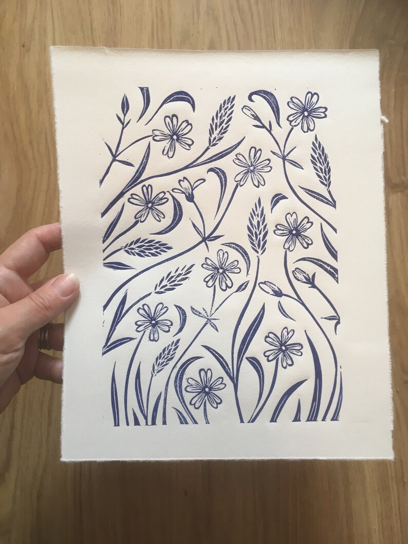 May include: A blue and white floral print on a white background. The print features stylized flowers and leaves.
