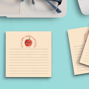 May include: Two cream-colored lined notepads with a red apple graphic and the text "Just an apple-a-day keeps the doctor away".