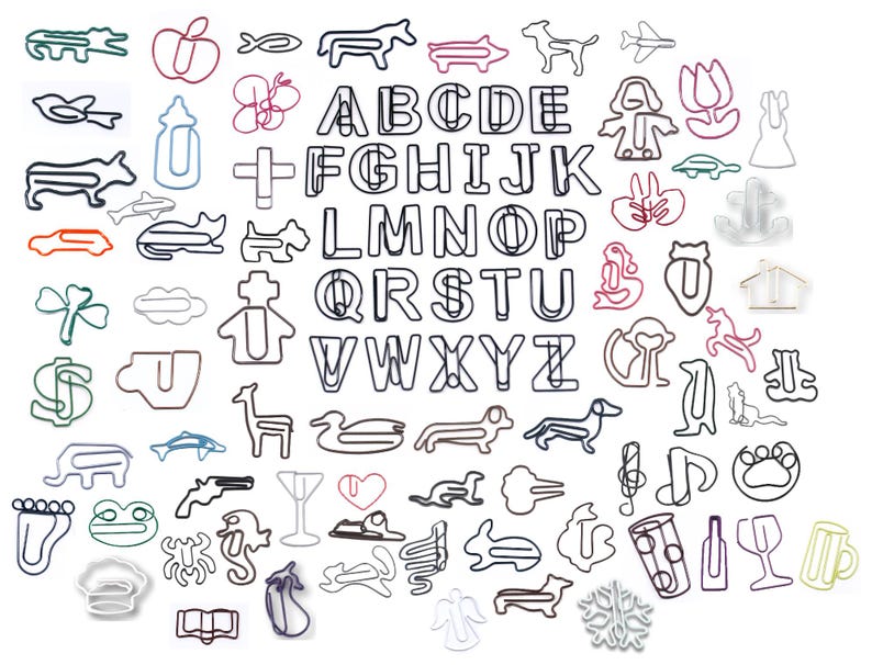 K&ouml;nnte beinhalten: Eine Sammlung dekorativer B&uuml;roklammern in verschiedenen Formen und Farben. Das Sortiment umfasst Buchstaben des Alphabets, Tiere und andere skurrile Designs. Die Klammern sind aus Metall und auf einer wei&szlig;en Oberfl&auml;che angeordnet.