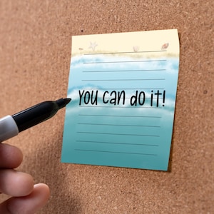 May include: A blue and yellow motivational note with a beach scene and the text "You can do it!" written in black marker.