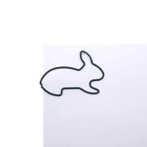 May include: A black wire rabbit shaped paperclip.