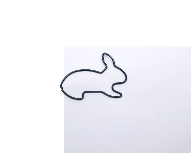 May include: A black wire rabbit shaped paperclip.