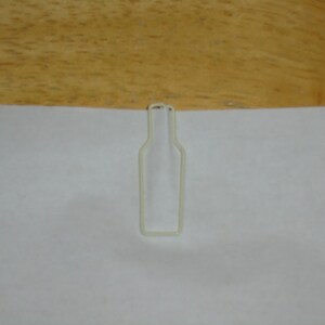 May include: White plastic bottle-shaped paper clip.