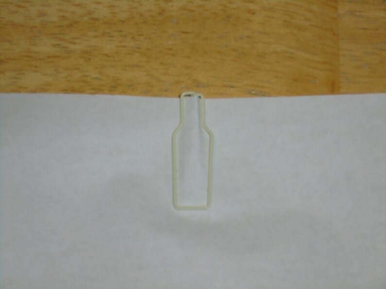 May include: White plastic bottle-shaped paper clip.