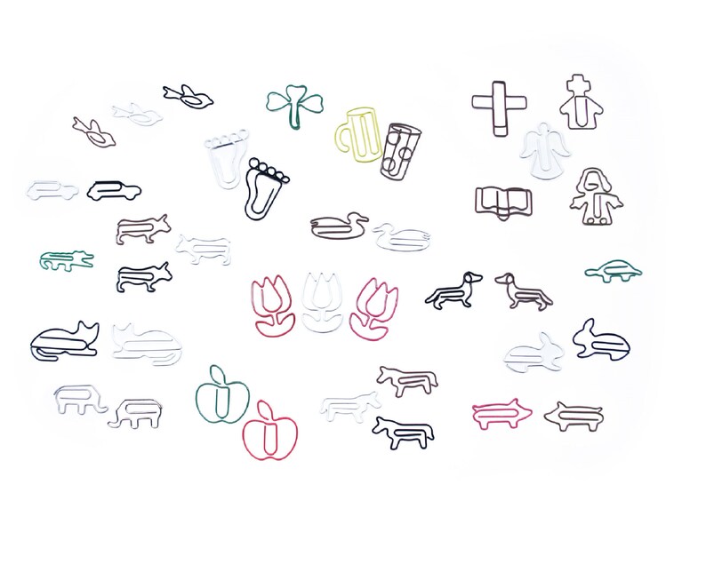 May include: A collection of colorful wire paper clips shaped like various objects, including a duck, a pig, a tulip, a cat, a fish, a cross, a book, a foot, a car, a bird, a mug, a shamrock, a turtle, an angel, a person, and a dachshund.