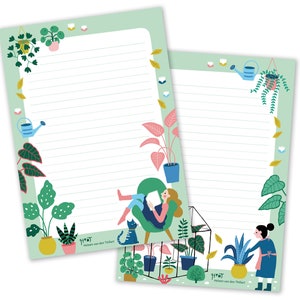 Op de afbeelding: Twee groene, gelinieerde notitieblokken met een groene rand en illustraties van planten, een kat en mensen. De tekst op het notitieblok zegt "9197 Helen van den Thillart".