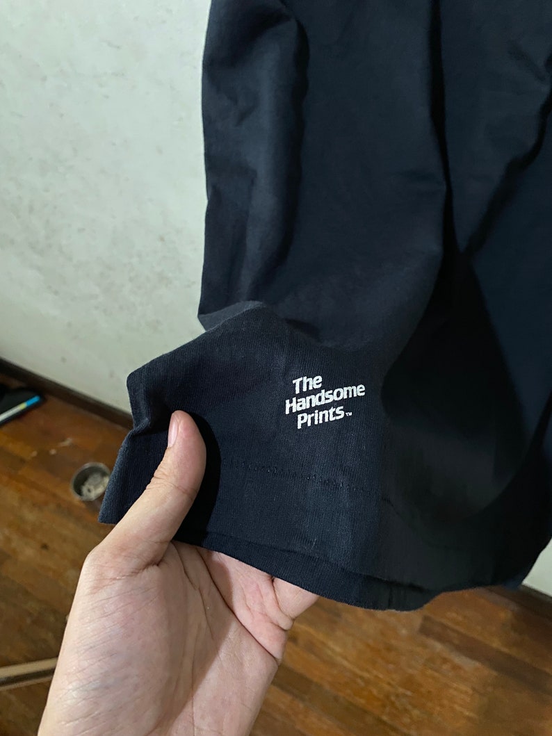 以下が含まれることがあります： 「The Handsome Prints.」という白い文字が書かれた黒いTシャツ
