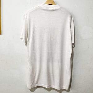May include: A white t-shirt with a crew neck and short sleeves.
