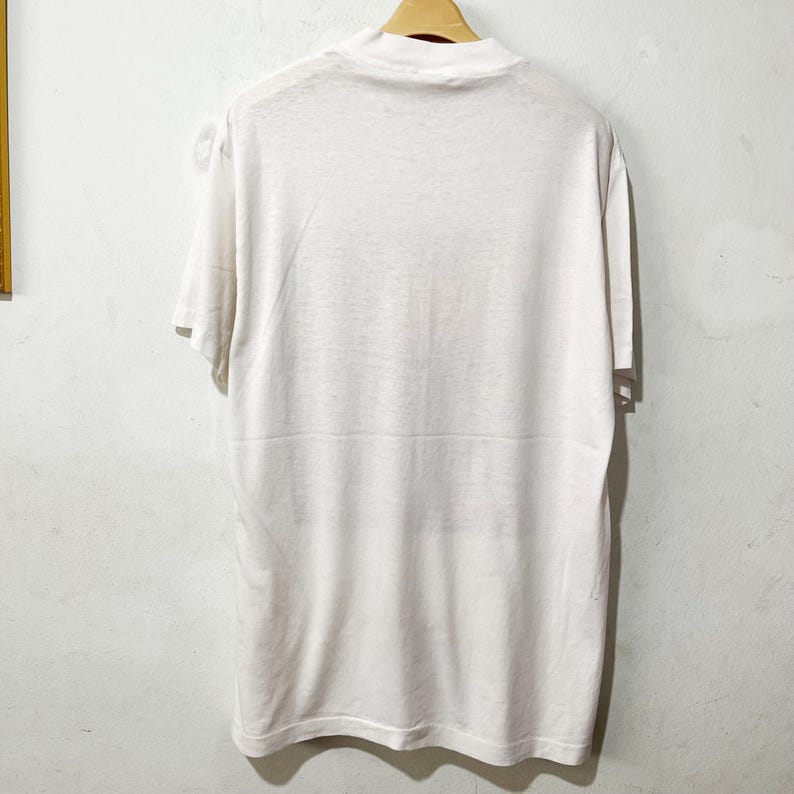 May include: A white t-shirt with a crew neck and short sleeves.