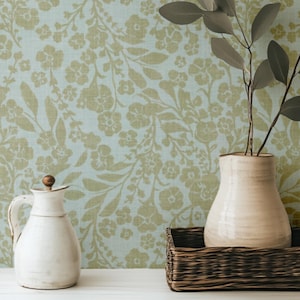 Soft green vintage floral wallpaper styled with ceramic vessels and leafy branches—perfect for cottagecore or French country interiors.