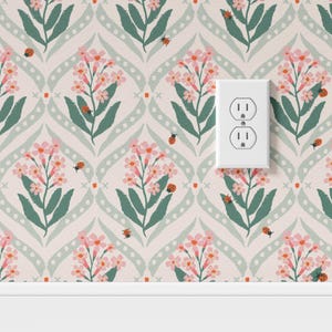 Pode incluir: Papel de parede floral com flores cor-de-rosa, folhas verdes e joaninhas sobre um fundo rosa claro. O design inclui um padr&atilde;o repetitivo de flores e folhas estilizadas, com uma tomada el&eacute;trica branca.