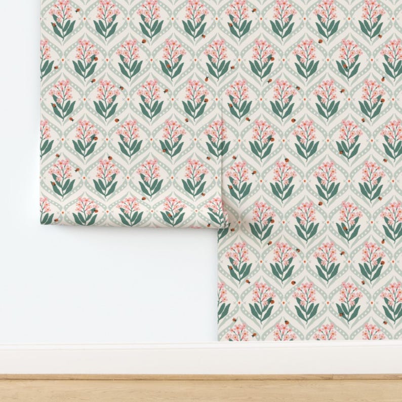 Pode incluir: Papel de parede floral com um padr&atilde;o repetitivo de flores cor-de-rosa, folhas verdes e pequenos insetos castanhos sobre um fundo bege claro. O desenho est&aacute; definido dentro de um padr&atilde;o de treli&ccedil;a em forma de diamante com um contorno verde suave. Um rolo de papel de parede &eacute; vis&iacute;vel.
