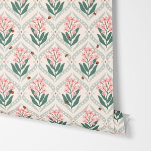 Pode incluir: Papel de parede floral com um padr&atilde;o repetitivo de flores cor-de-rosa, folhas verdes e pequenas joaninhas vermelhas sobre um fundo creme. O design apresenta um padr&atilde;o de treli&ccedil;a claro, verde, pontilhado e curvo.