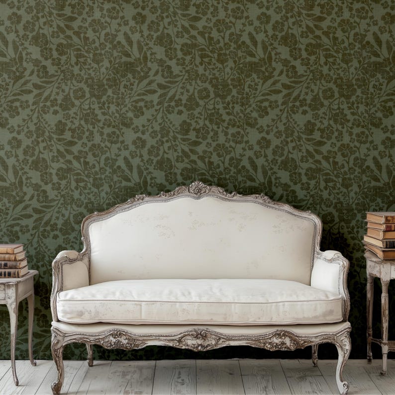 Elegant white vintage sofa with ornate carvings sits in front of floral green wallpaper. Stack of books on side tables evoke a classic, cozy ambiance.