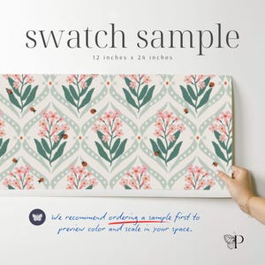 Pode incluir: Uma amostra de padr&atilde;o floral, 30.5 cm x 61 cm, com um design repetido de flores cor-de-rosa, folhas verdes e joaninhas sobre um fundo claro. O texto "swatch sample" est&aacute; no topo. O texto "We recommend ordering a sample first to preview color and scale in your space" est&aacute; na parte inferior.