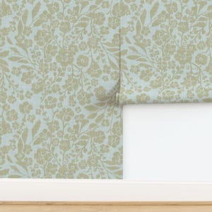 K&ouml;nnte beinhalten: Ein hellblauer Hintergrund mit einem sich wiederholenden Muster aus beigen floralen Zweigen und Bl&auml;ttern.