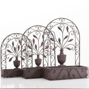 May include: Three decorative metal wall planters in varying sizes. Each planter features a dark brown arched frame with a vase-shaped container holding stylized leaves. The planters have a rectangular base with decorative scrollwork.