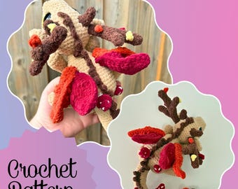 Puede incluir: Patrón de dragón tejido a ganchillo en beige, marrón, rojo y rosa. El dragón tiene cuernos, alas y detalles de setas. La imagen incluye el texto "Crochet Pattern".