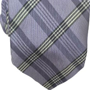 May include: A lavender plaid necktie with a diagonal pattern of black and white stripes. The tie is made of a woven fabric and is suitable for formal or business attire.