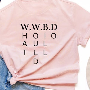 Può includere: Una maglietta rosa con il testo "W.W.B.D. H.O.I.O. A.U.L. T.L.L. D" in nero.