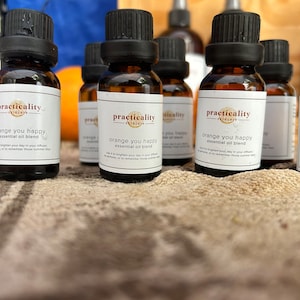 May include: A collection of amber glass bottles with black lids and white labels. The labels have the text "practicality skincare" and "orange you happy essential oil blend".
