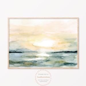 Könnte beinhalten: Ein rechteckiger Wandkunstdruck in einem hellen Holzrahmen mit einem Aquarellgemälde eines Sonnenuntergangs über einem Gewässer. Der Himmel ist in sanften Gelb- und Pfirsichtönen gehalten, während das Wasser in gedeckten Blau- und Grautönen dargestellt ist.