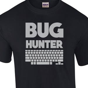 May include: Black t-shirt with the text "BUG HUNTER" in white and a keyboard graphic below it.