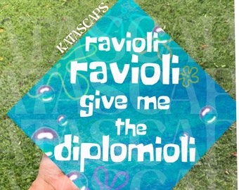 May include: A blue graduation cap with the text "Ravioli Ravioli give me the diplomioli" in white. The cap has a cartoon-like design with bubbles and a starfish.
