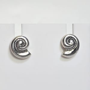 May include: Pair of silver-toned stud earrings. Each earring features a spiral design with a beaded edge. The earrings are displayed on a white background.