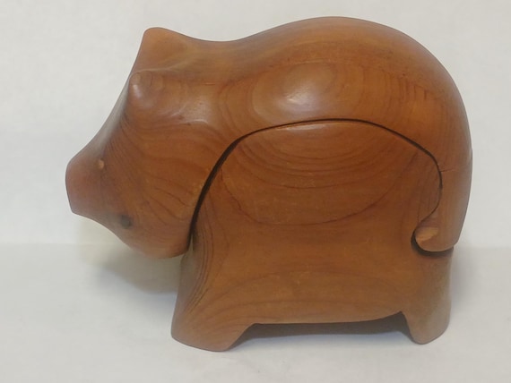 A signed, hand-carved wooden pig puzzle box by Vermont artist Deborah D. Bump — a mid-century collectible with a secret compartment that's as much folk art as it is functional trinket box.