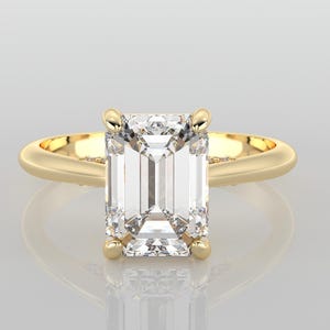 May include: A gold ring with an emerald cut diamond.