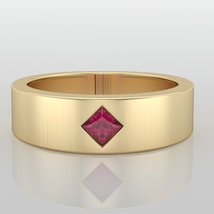 May include: A gold band ring with a square, ruby-colored gemstone set in the center. The ring has a flat, wide band and a polished finish. The gemstone is a deep red color.
