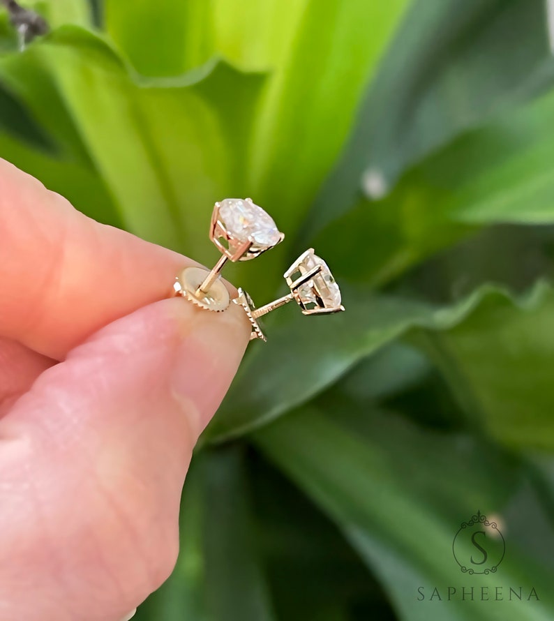May include: A pair of gold stud earrings with round, clear gemstones.