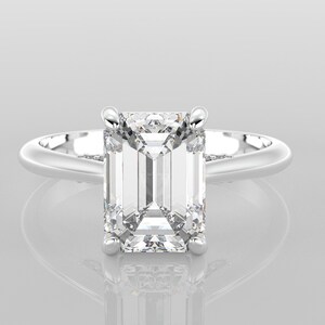 May include: A silver engagement ring with a large, clear emerald-cut diamond.