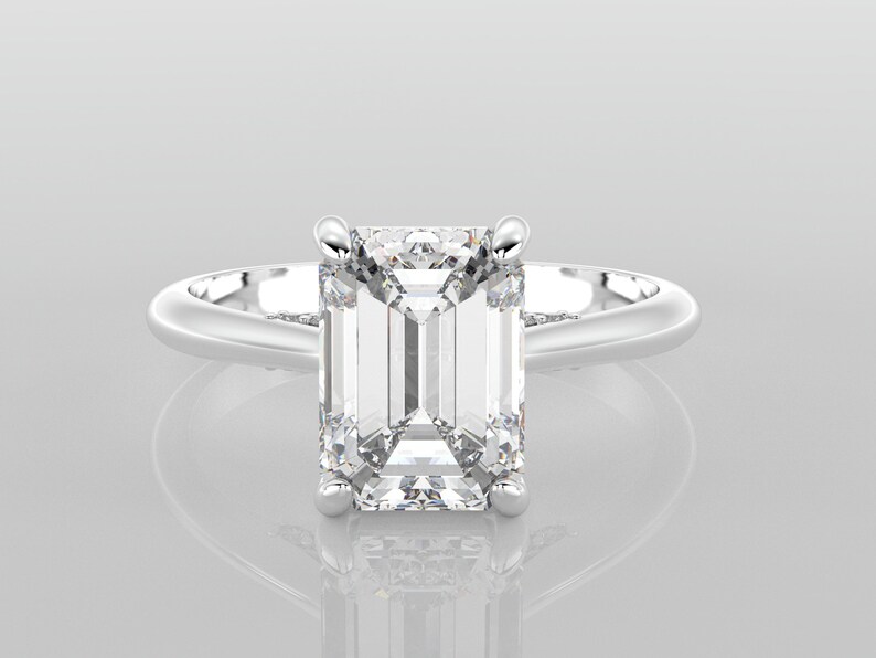 May include: A silver engagement ring with a large, clear emerald-cut diamond.